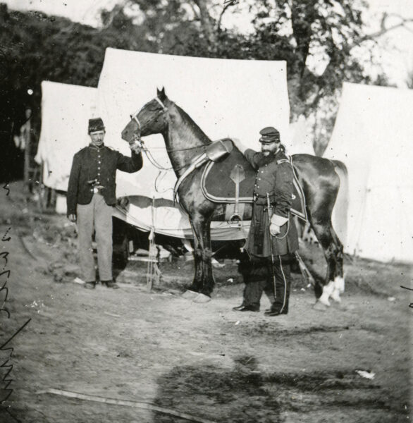 Photo of two Civil War soldiers and a horse at camp taken by Mathew B. Brady.
