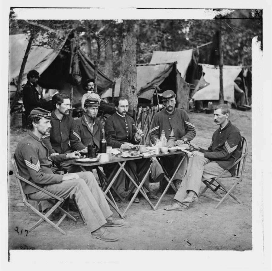 Non-commissioned officers of Co. D, 93rd New York Infantry, dine in the regimental camp at Bealeton, Virginia, in this image from August 1863.