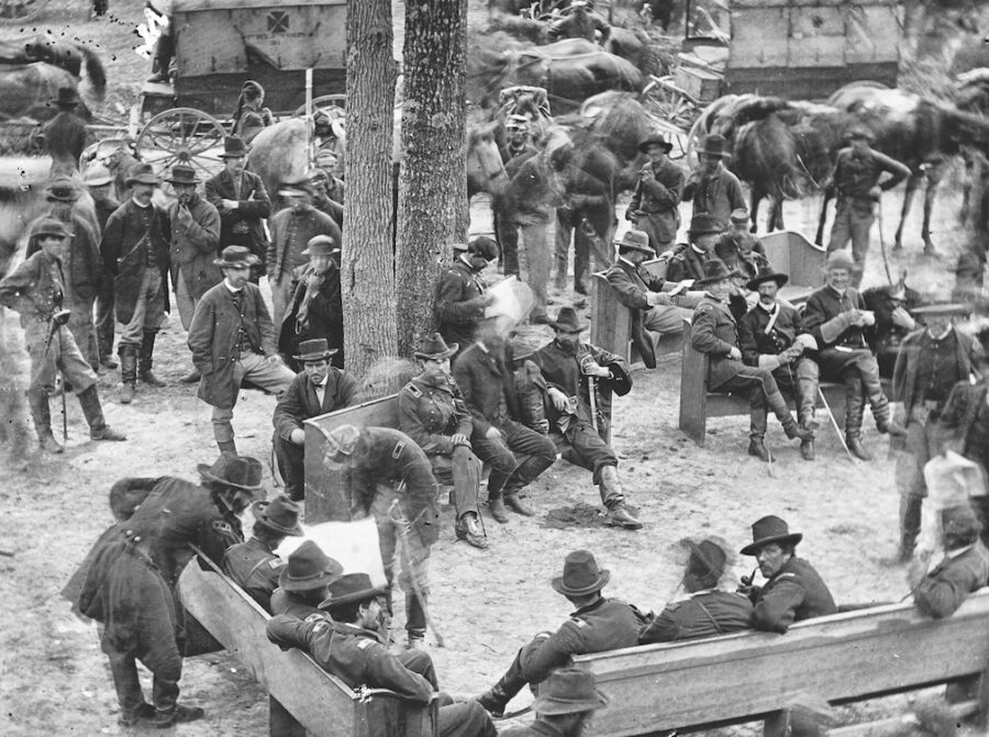 On May 21, O’Sullivan lugged his bulky camera up to the second floor of Massaponax Church, where Grant and others had stopped as the army moved ever southward. O’Sullivan captured three photos of history in the making. In the scene above, Grant (standing, lower left) is leaning over the right shoulder of General George Gordon Meade, commander of the largest force under Grant’s command—the Army of the Potomac. The two highest ranking Union men in the Overland Campaign examine a map while the army moves past at top.