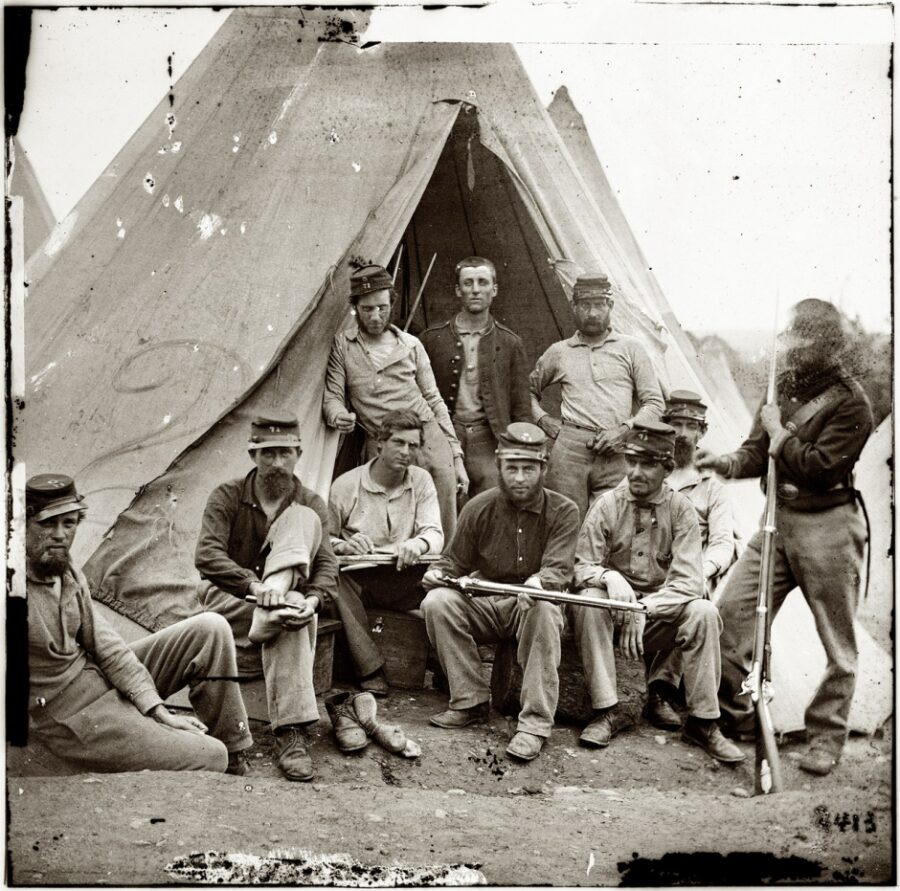 A group of Union soldiers belonging to Company G of the 71st New York Infantry pose for the camera in front of a Sibley tent in 1861.