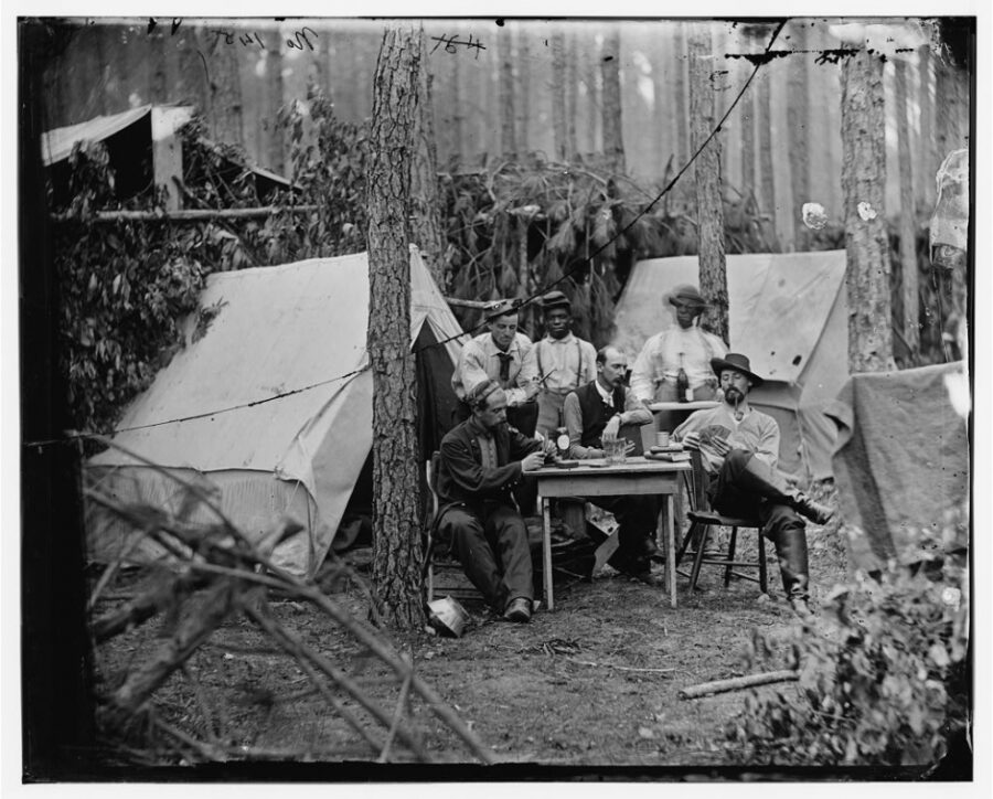 Officers from the 114th Pennsylvania Infantry play cards in front of their wall tents in camp at Petersburg, Virginia, in August 1864.