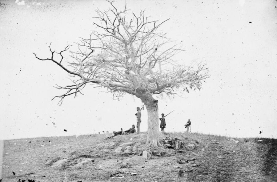 Union soldiers stand near the grave of a recently buried comrades on the Antietam battlefield