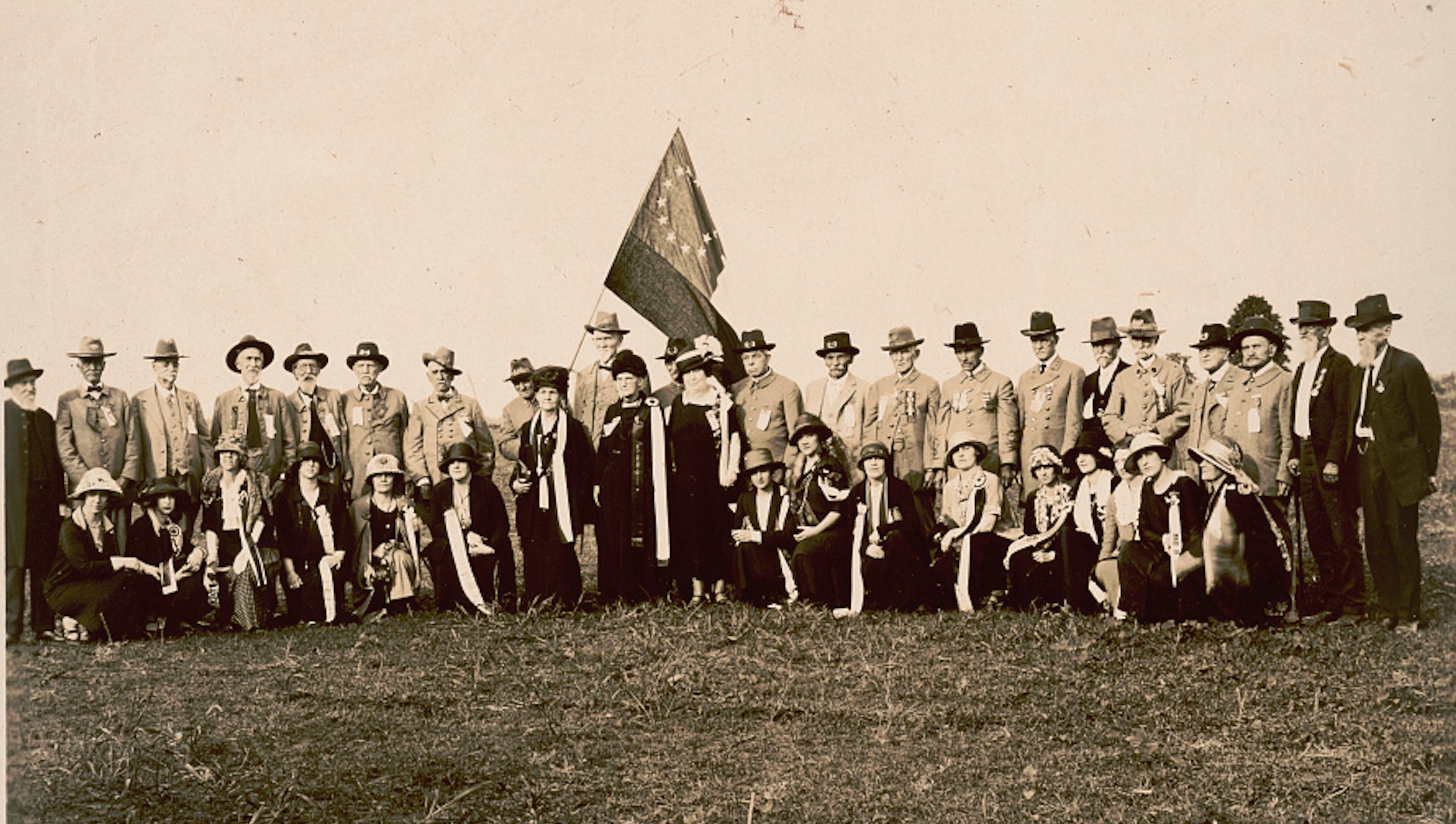 A group of veterans fly a Confederate flag at a UCV reunion in Ford City, Alabama, circa 1924.