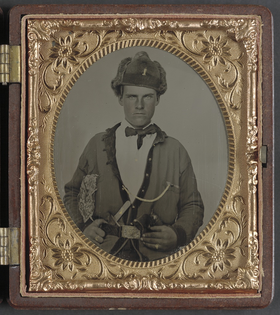 Unidentified soldier in Union uniform, U.S. cavalry belt, and fur hat bearing number 1, with Bowie knife and revolver