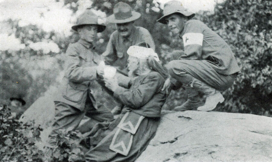 Red Cross volunteers help a Gettysburg veteran in the field during a reunion.