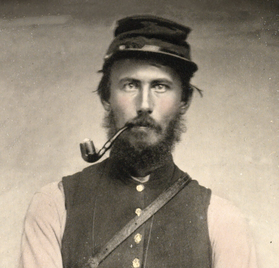 Civil War soldier smoking a pipe.