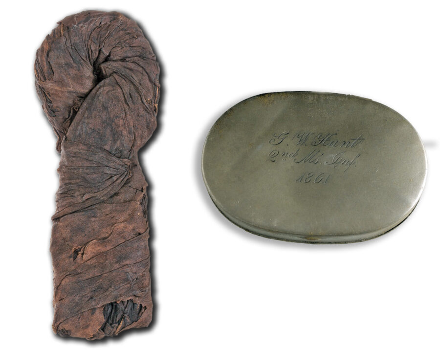 A plug of tobacco that dates from the Civil War and an engraved metal snuffbox carried by a soldier in the 2nd Massachusetts Infantry.