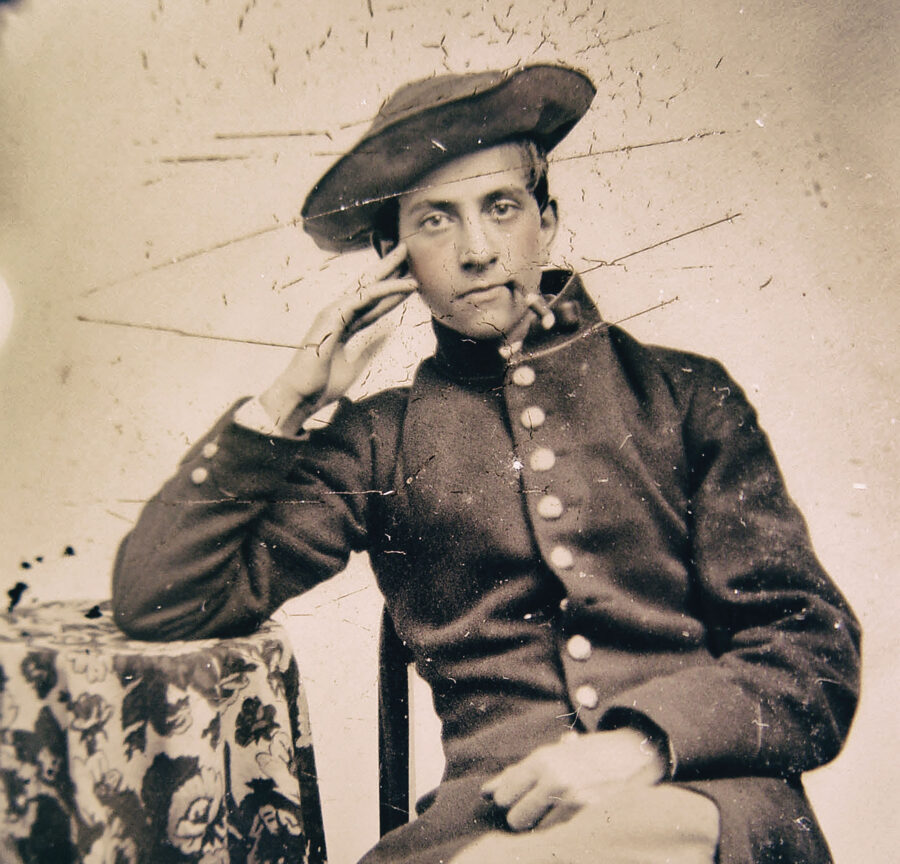 A young Civil War soldier smokes a cigar.