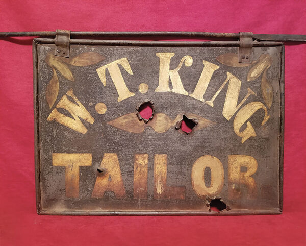 William T. King’s downtown tailor shop sign with bullet holes.