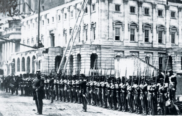 Union troops standing at attention in front of the capitol building.