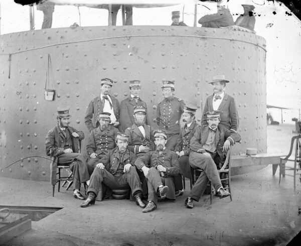 Officers on deck of USS Monitor on the James River on July 9, 1862, photographed by James Gibson. Two men in the group would not survive the year: 3rd Assistant Engineer Robinson Hands (front row, left) and Acting Ensign George Frederickson (second row, second from left, directly behind Hands) drowned in the storm that sank their ironclad off Cape Hatteras.