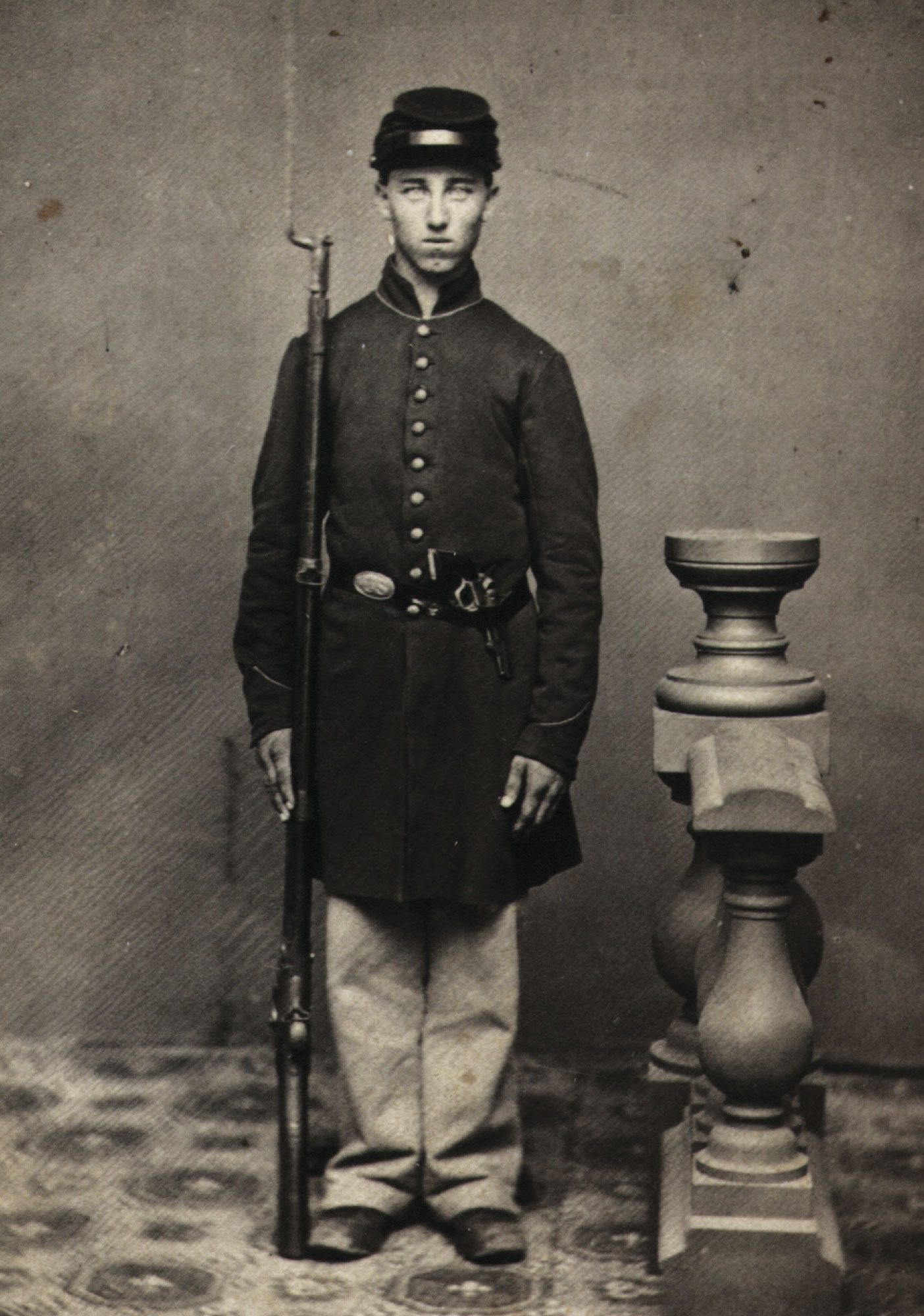 Large portrait of Hiram H. Davis, Private, 10th Vermont Infantry, standing at attention with rifle.