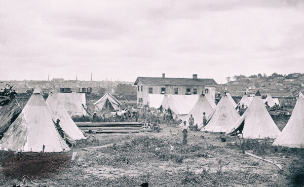 Former slaves mill about the grounds of a “contra-band camp”—one of over 300 such settlements established in Union-occupied regions during the conflict—in Richmond, Virginia, in 1865.
