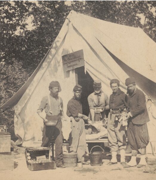 A surgeon in the 74th New York Infantry prepares to perform an amputation on a member of the regiment outside the surgeon's tent at camp near Washington, D.C.